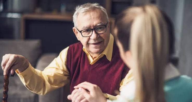 Pessoa idosa conversando com um familiar em ambiente acolhedor